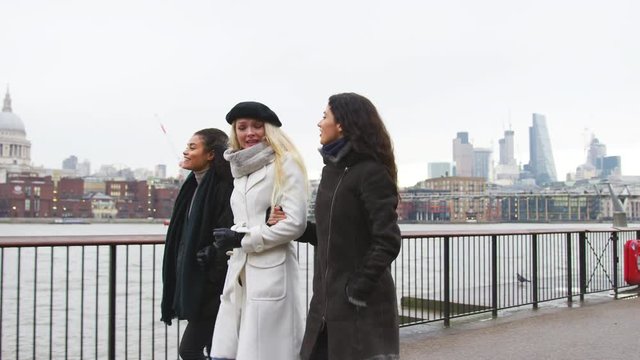 Female Friends Walk Along South Bank On Winter Visit To London