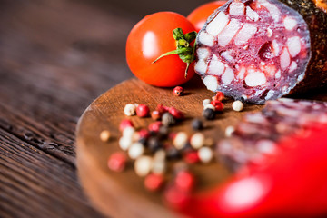 Tasty salami with tomatoes and peppercorn close
