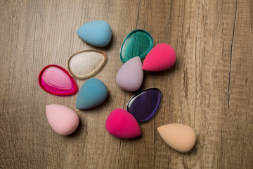Obraz na płótnie Canvas Closeup shot of beauty blenders and silicone sponges on a wood background. Space for text