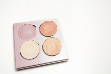 Set of holographic makeup highlighters on a white background