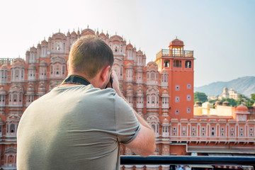 Male traveler takes picture of Hawa Mahal in India