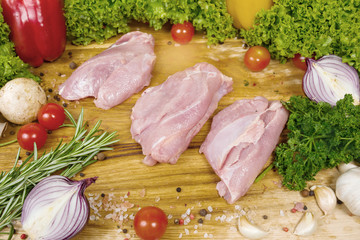 Raw chicken fillet on a wooden board