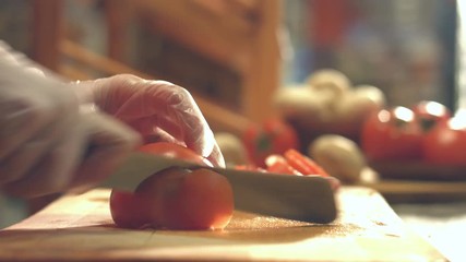 Cutting tomatoes on a cutting board.
Close-up. Slow motion. Focus in.
Female hands cut the tomato into slices. - Powered by Adobe