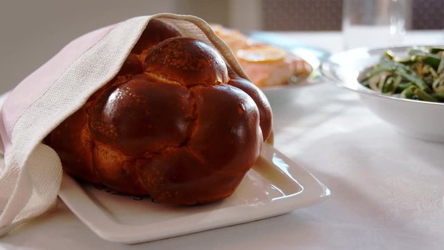 Challah bread on a table set for Jewish Shabbat, close up