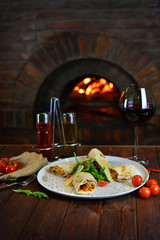 Tasty dish with a glass of wine in a restaurant with fire stone stove