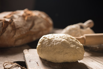 Freshly baked bread on wooden table on dark background