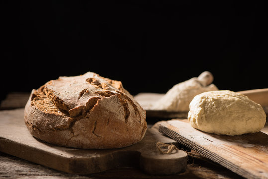 Freshly baked bread on wooden table on dark background