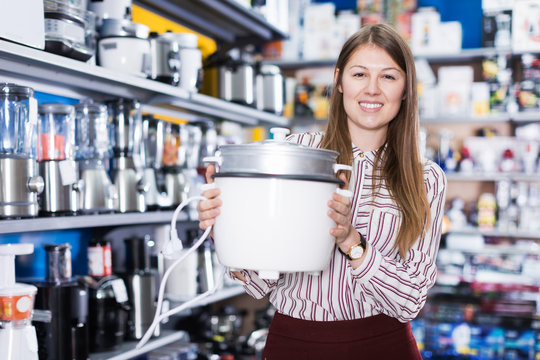 Saleswoman offering slow cooker in household appliances shop