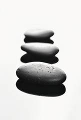 Massage stones. Czarne kamienie bazaltowe, układ perspektywiczny ostre, głębokie cienie