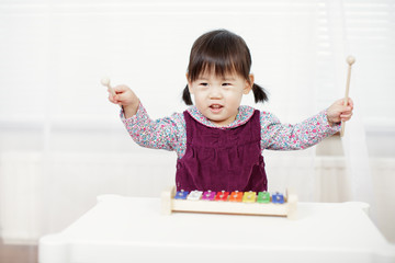 baby girl play xylophone at home