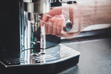 Preparing coffee in a coffee machine. The man assembles a coffee machine grinder. Time for a break, time for coffee. Black ground coffee, coffee machine. The concept of acquiring energy.