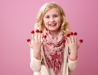 happy child isolated on pink with raspberries on fingers