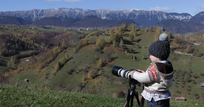 Little boy photographs the nature, autumn mountain landscape