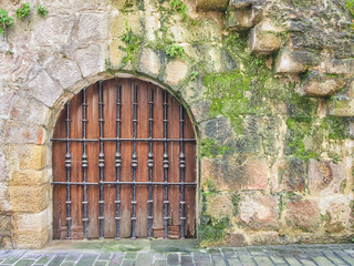 Wooden door in the medieval stone wall