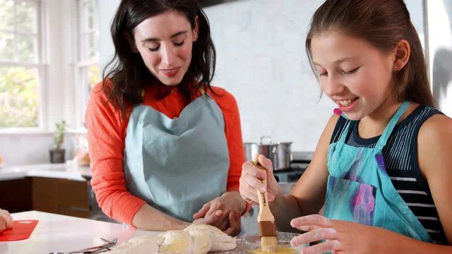 Jewish mother and daughter preparing glaze for challah bread