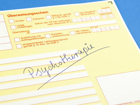 &Uuml;berweisungsschein mit der Aufschrift Psychotherapie auf blauem Hintergrund, Textfreiraum