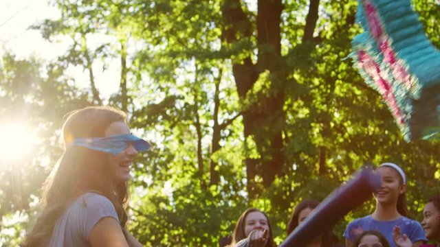 Girls watch their friend hitting a pi&ntilde;ata on her birthday