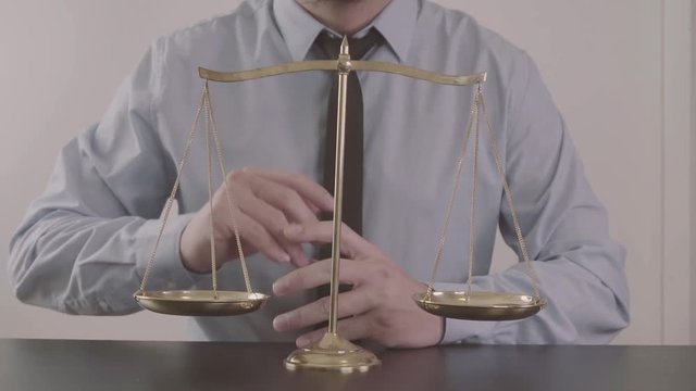 justice and law concept.Male lawyer in the office with brass scale on wooden table
