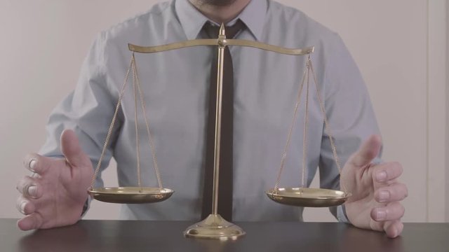 justice and law concept.Male lawyer in the office with brass scale on wooden table
