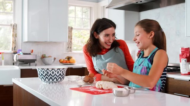 Jewish mother and daughter preparing dough for challah bread
