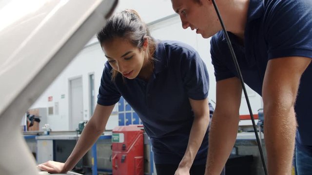 Two Trainee Mechanics Studying Car Engine At College