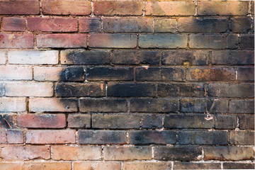 Close-up of red brick wall with blac, white and yellow paint