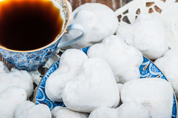 Coffee in blue cup and glazed gingerbread in white sugar glaze on a porcelain saucer