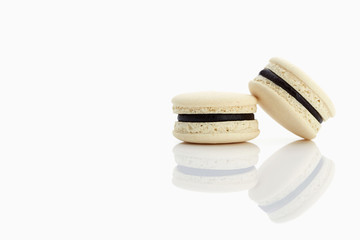 Assorted macaroons over white background with reflection.