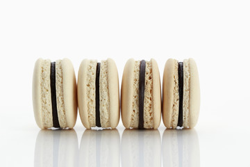 Assorted macaroons over white background with reflection.