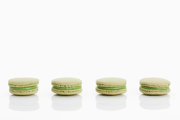 Assorted macaroons over white background with reflection.