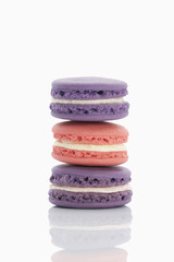 Assorted macaroons over white background with reflection.