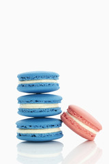 Assorted macaroons over white background with reflection.