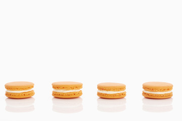 Assorted macaroons over white background with reflection.