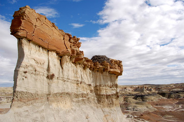cliff like rock formation in badlands with eagles nest and white clouds in the Bisti De Na Zin wilderness in Northern New Mexico