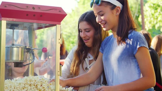 Teen girls serving popcorn at a neighbourhood block party