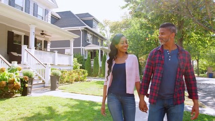 Couple Walking Along Suburban Street Holding Hands - Powered by Adobe