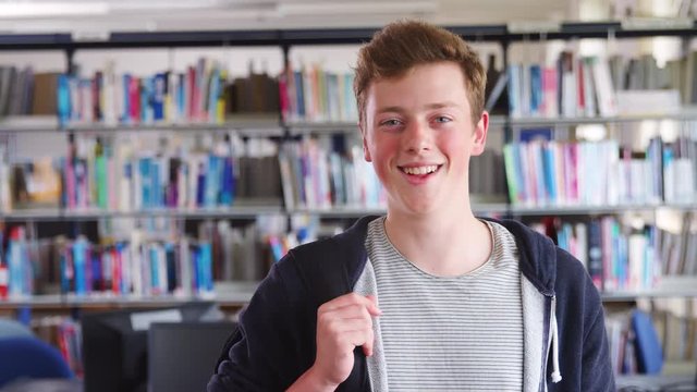 Portrait Of Male Student Standing In College Library