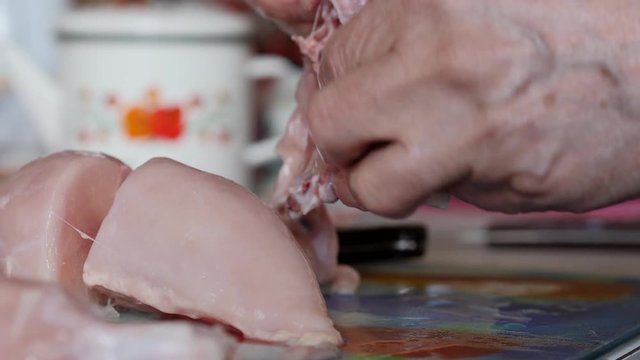 The Hands Of An Elderly Man Cut A Piece Of Chicken