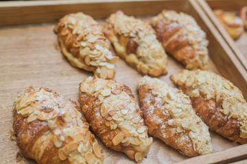 Traditional French breakfast croissant with almonds on the stove. On the tray.