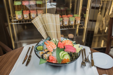 Sushi Set sashimi and sushi rolls served on stone slate