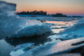 Panorama frozen river view at twilight and sunset with ice floes. Elbe Hamburg Northern Germany