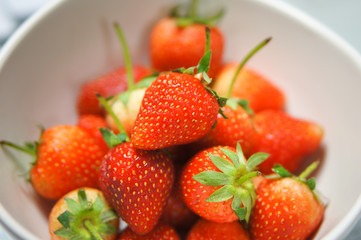 fresh strawberries in ceramic bowl on white background. 
