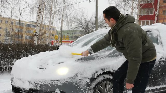 Man removing the snow on the car
