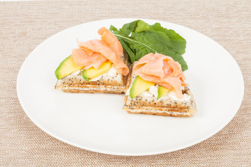 Healthy  breakfast  waffles with avocado and salmon