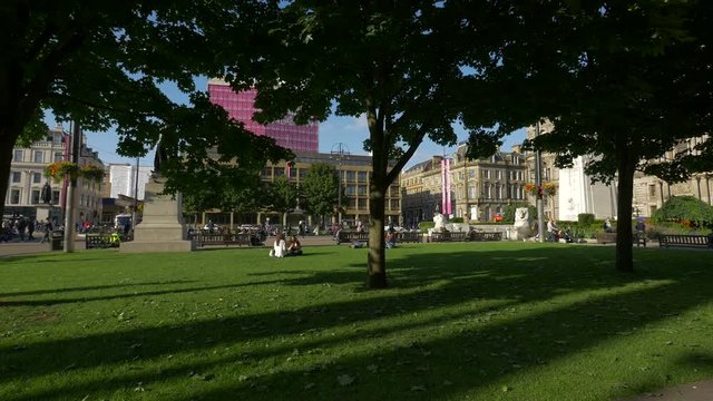 Trees and green grass in a city square