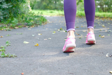 Walking and jogging woman with athletic legs and running shoes, close up, Copyspace for your text