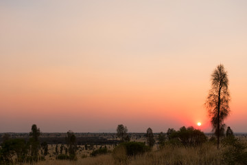 Sun setting in a  smoke filled sky in the outback of the Northern Territory in Australia