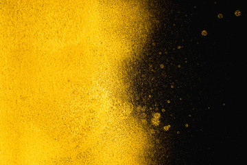 Golden abstract grainy texture on black background