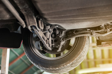 Close up tire wheel bush-bolt under double wishbone suspension car lift 