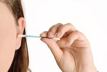 Close up of woman cleaning her ear with a cotton swab